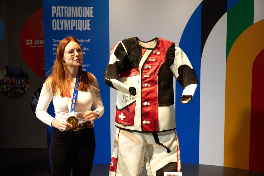 Nina Christen im Olympischen Museum mit ihrer gespendeten Schiessbekleidung